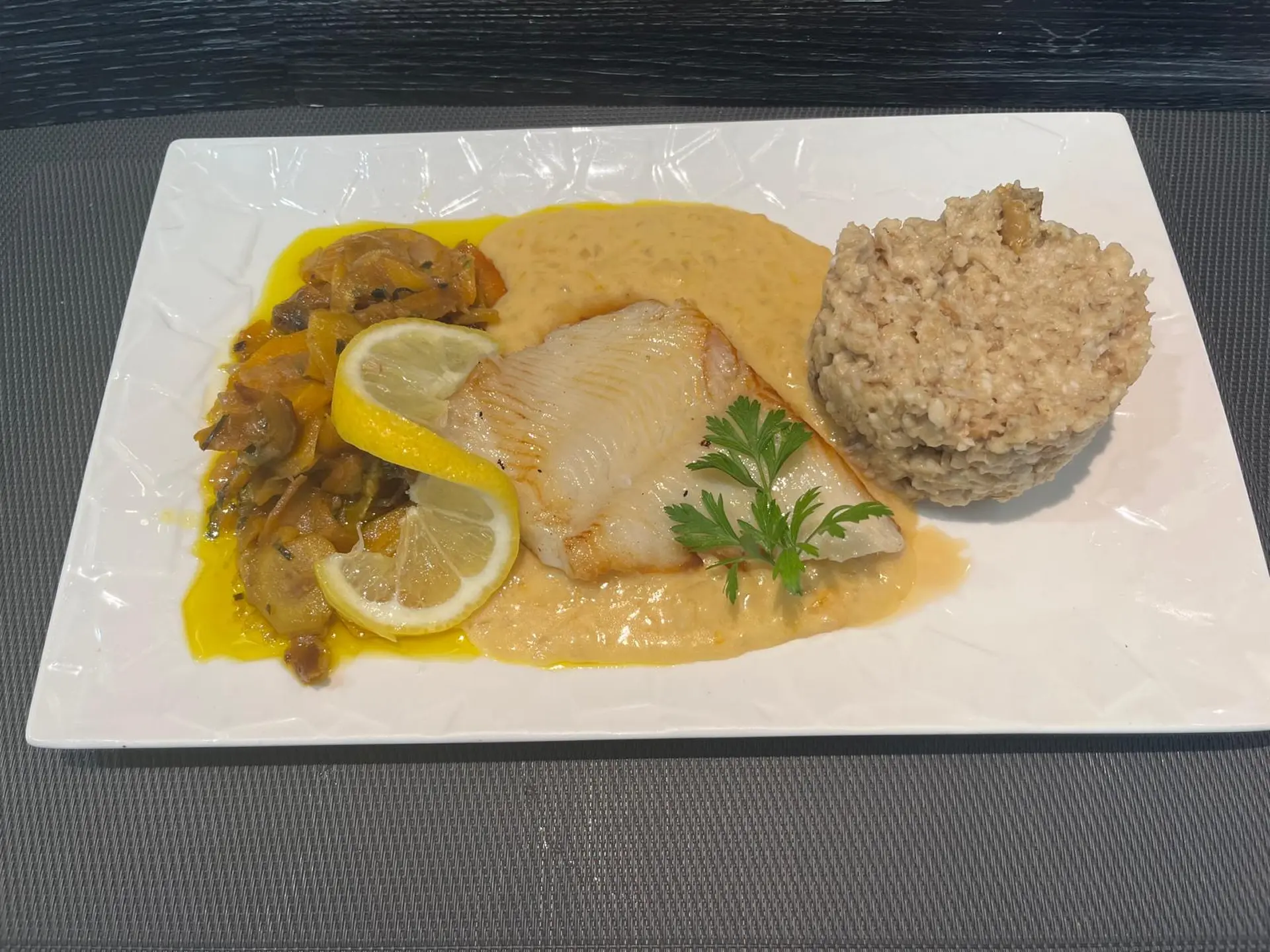Filet de flétan sauce aux agrumes, risotto aux cèpes et trio de carottes