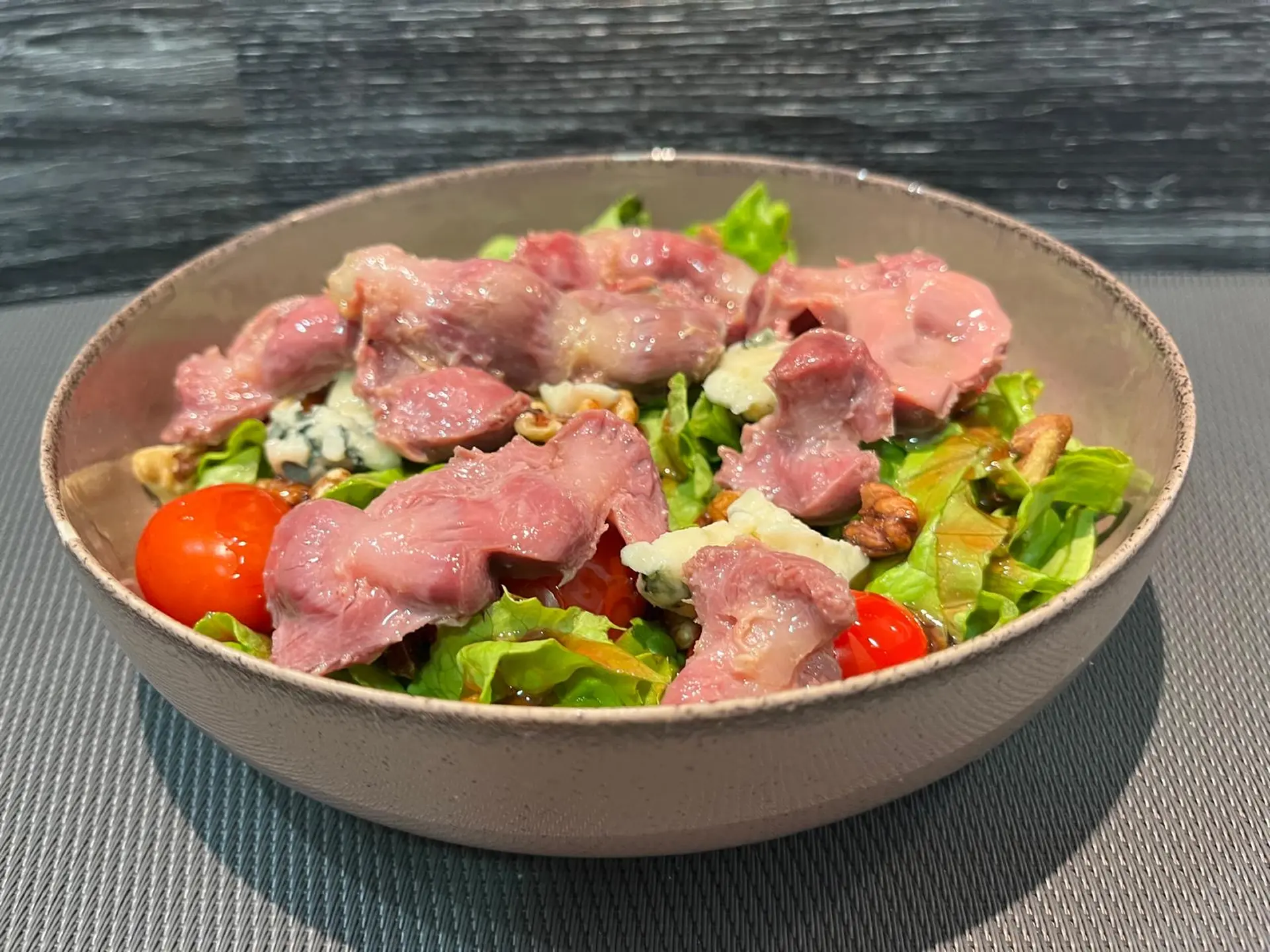 Salade Gourmande : salade, gésiers, roquefort, tomate et noix, crème de framboise